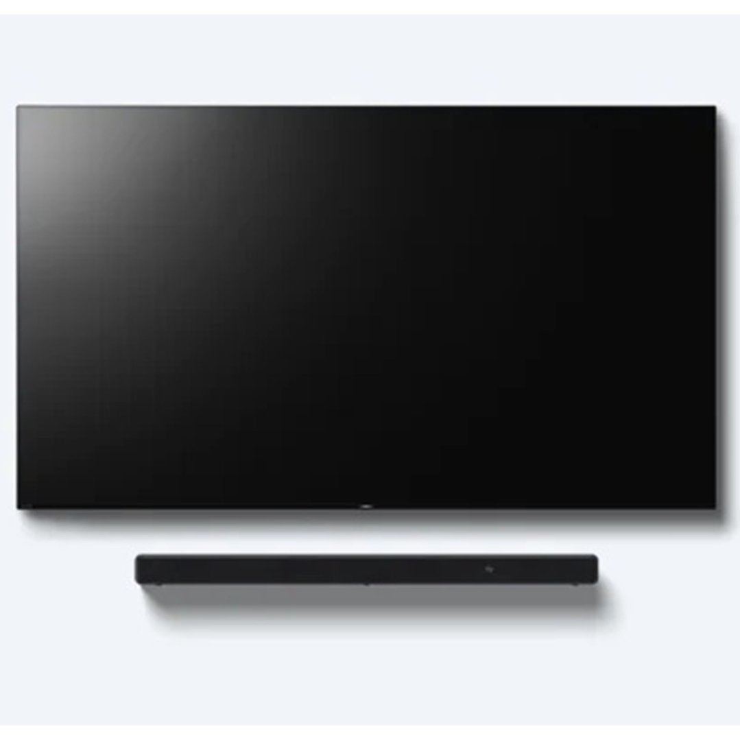 Black soundbar positioned below a large black flat-screen TV on a white wall
