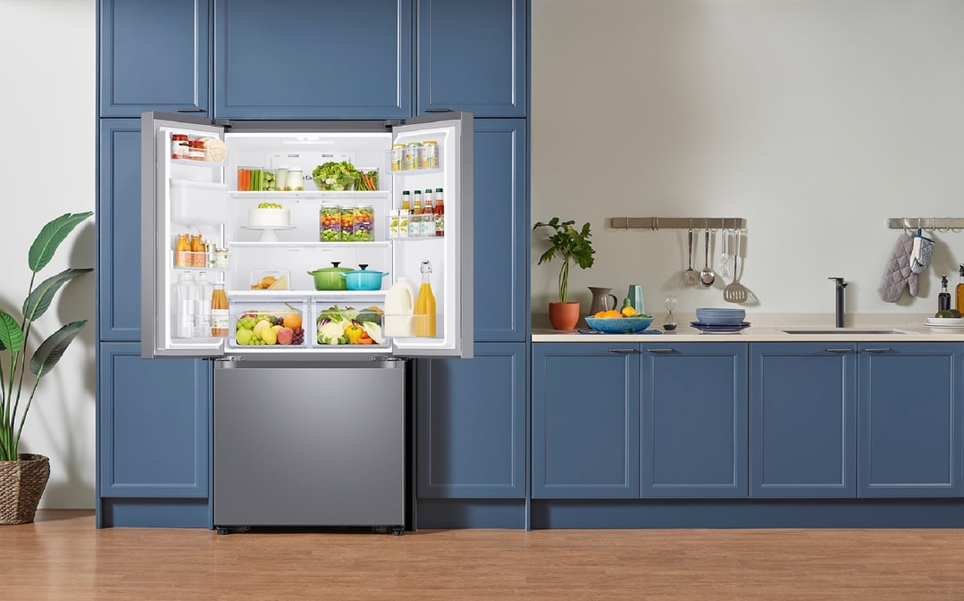 Open French Door Refrigerator filled with food in a blue kitchen
