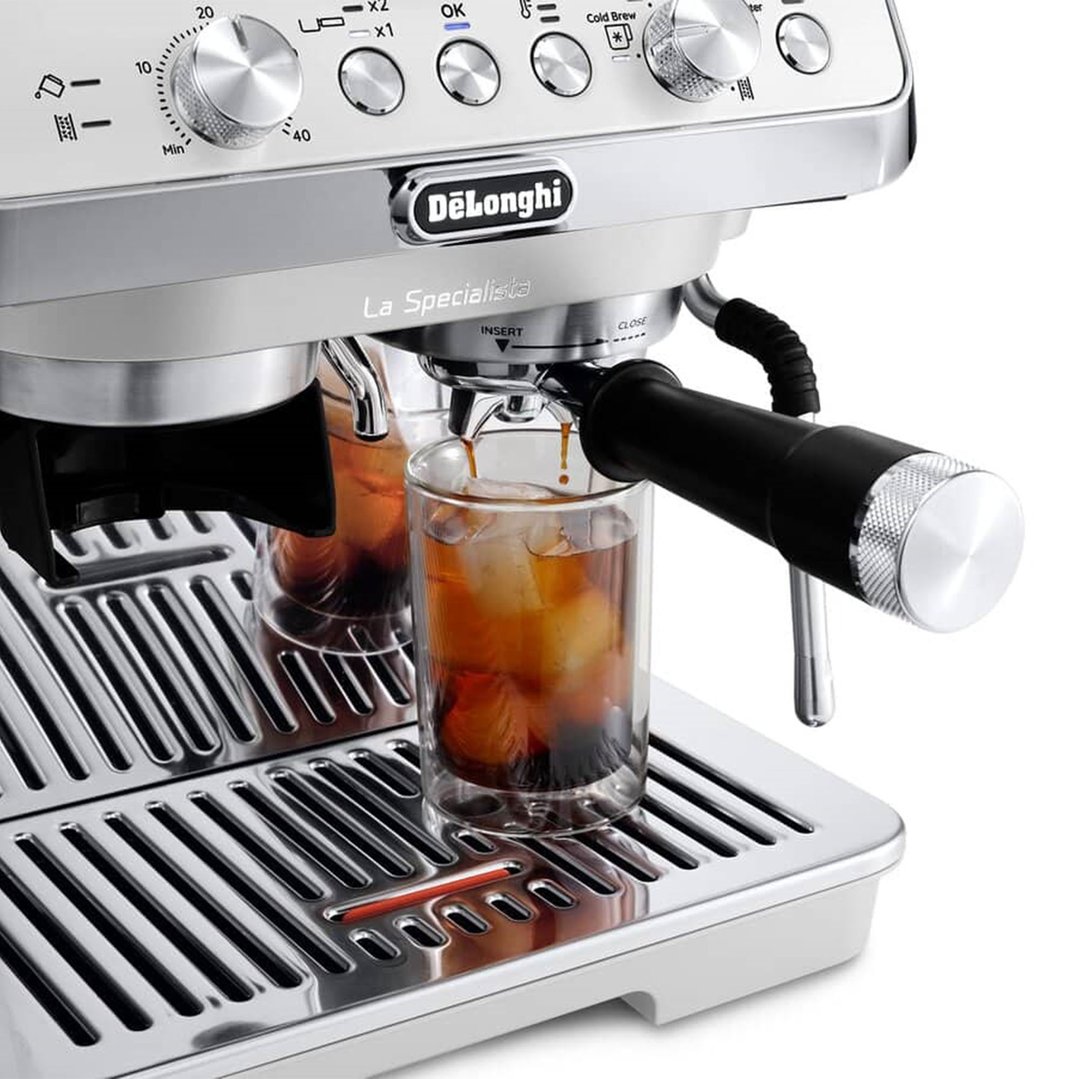 Close up of a coffee machine dispensing coffee into a glass with ice