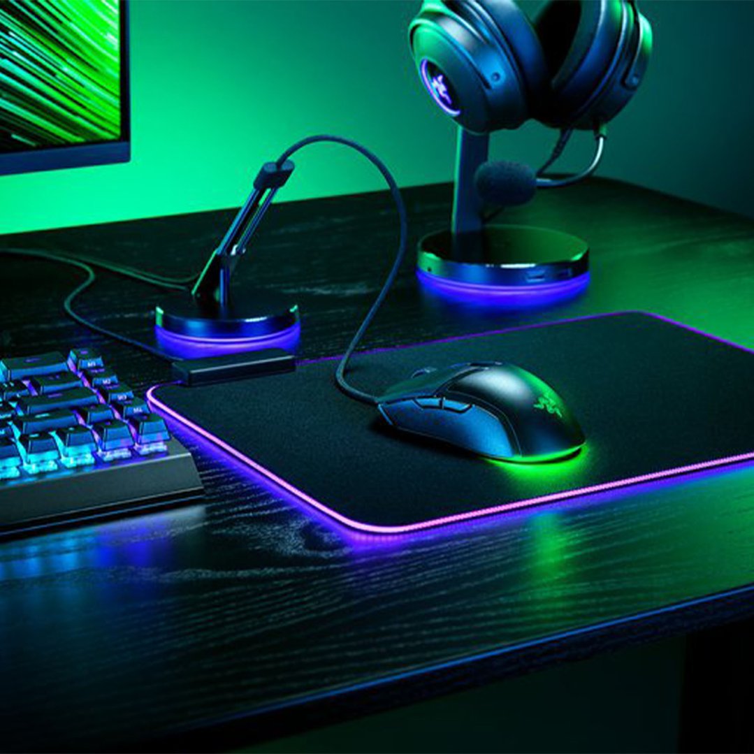 Gaming mouse on a mousepad with keyboard, headset, and monitor on a desk