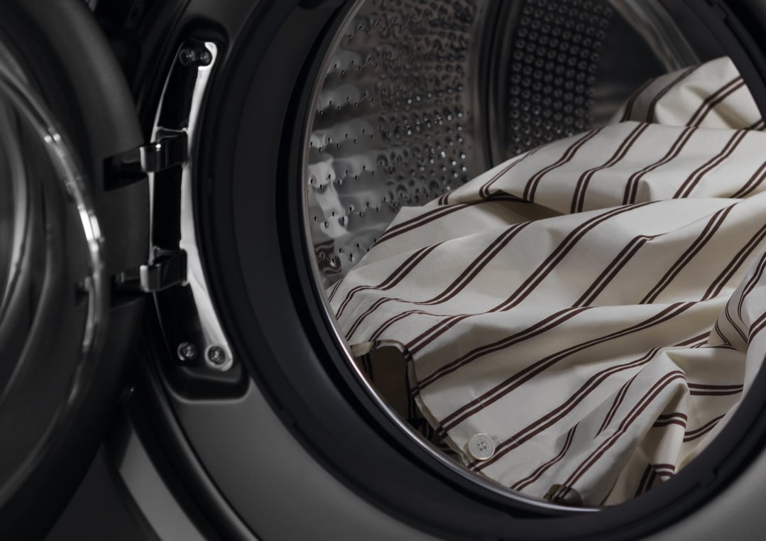 Close up of striped laundry inside a front loader washer dryer combo