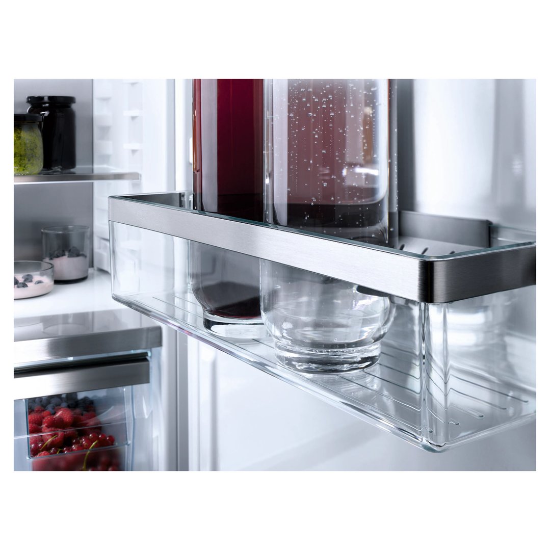 Close up of a fridge interior with drinks, jars, and berries