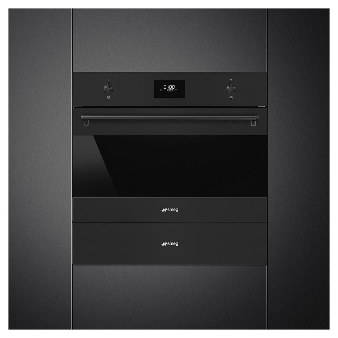 Black built-in oven and two warming drawers in a dark kitchen cabinet setting