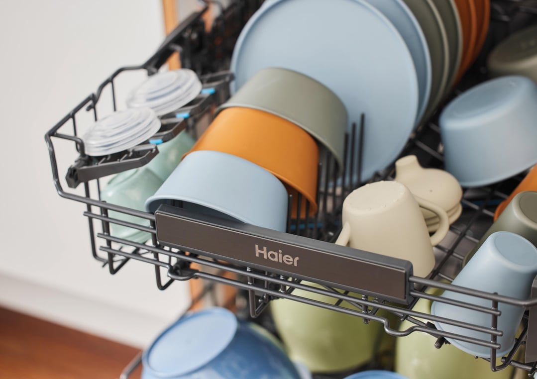 Close up of a Haier dishwasher rack filled with colorful dishes