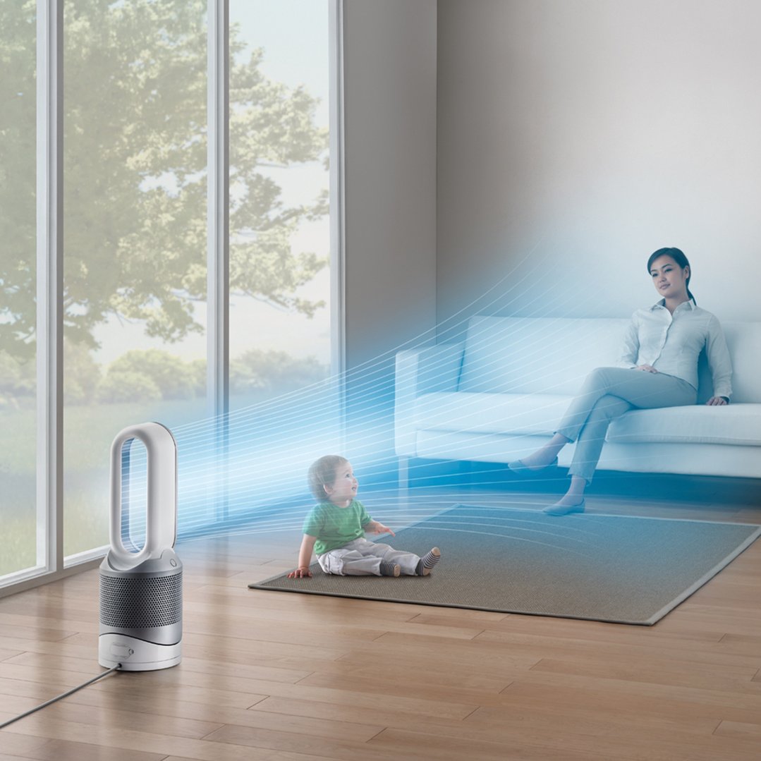 A Dyson air purifier directs airflow towards a woman and child in a living room