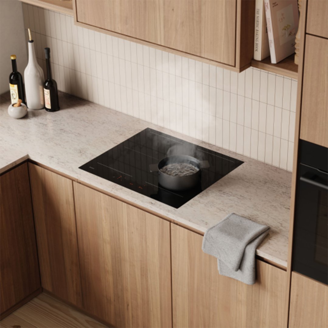 Black glass ceramic induction cooktop with a pot boiling in a modern kitchen
