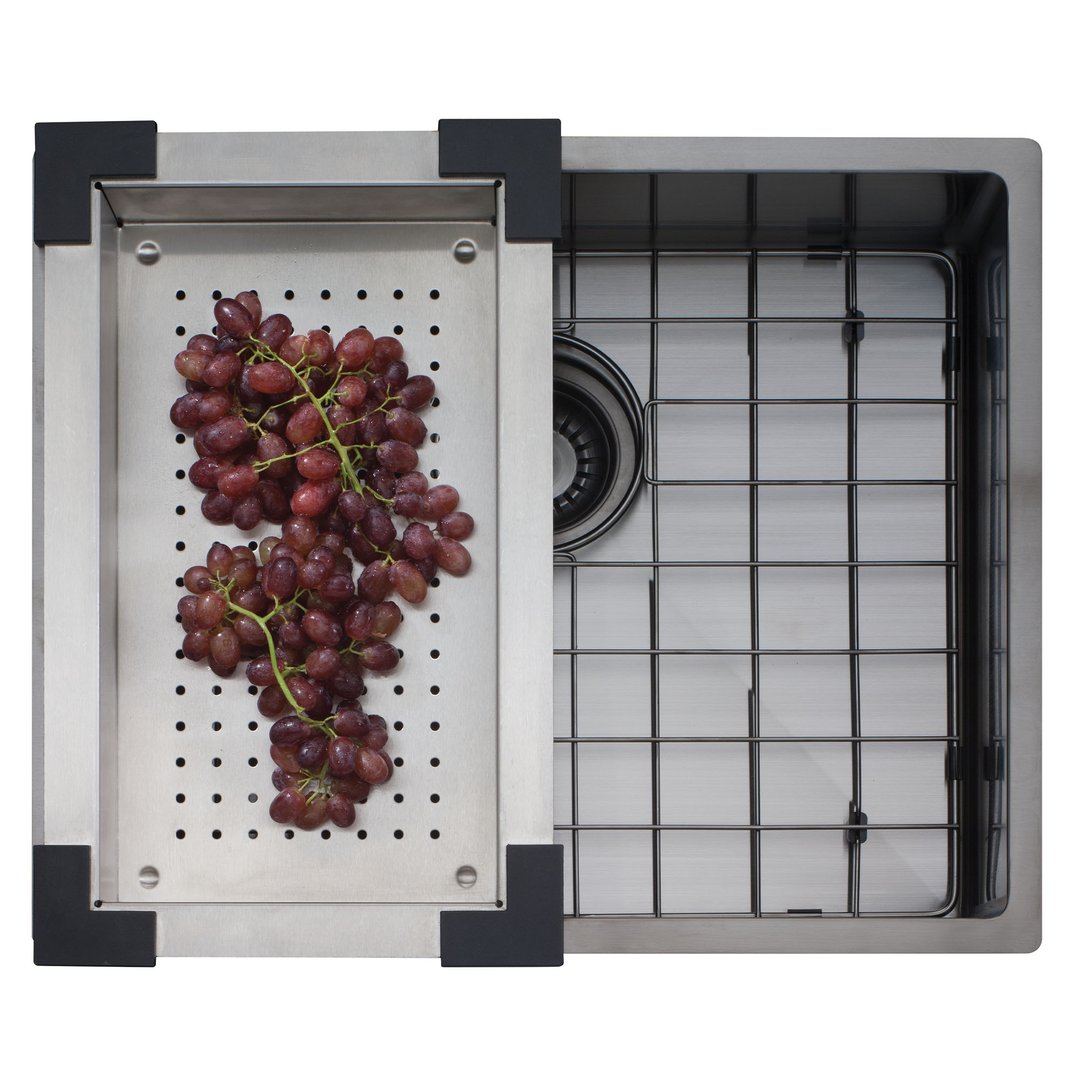Overhead view of a gunmetal sink with a colander full of grapes