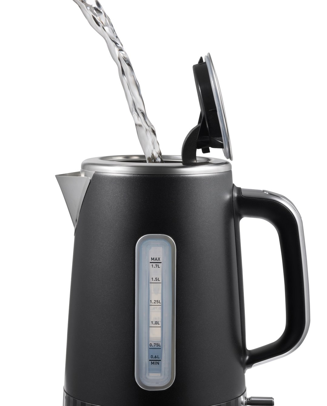 Water pouring into a black electric kettle with an open lid