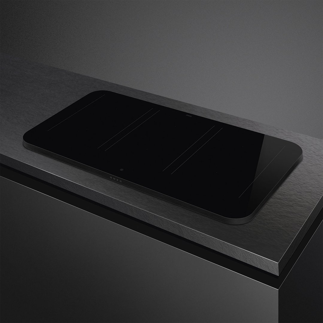 Matte black induction cooktop with autovent built into a dark kitchen counter