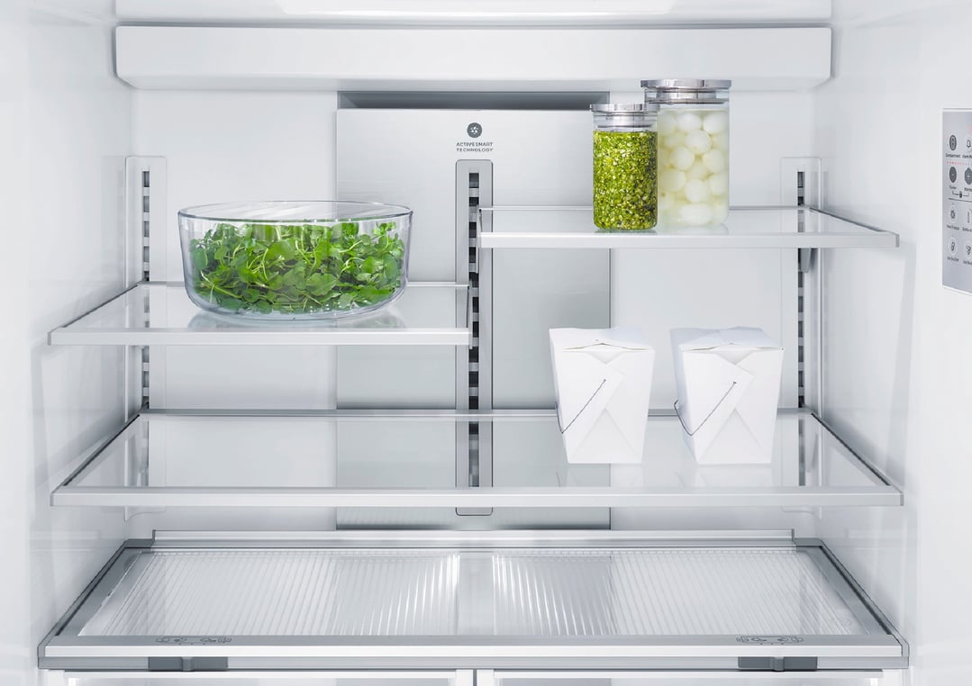 Interior view of a refrigerator freezer with food items on glass shelves