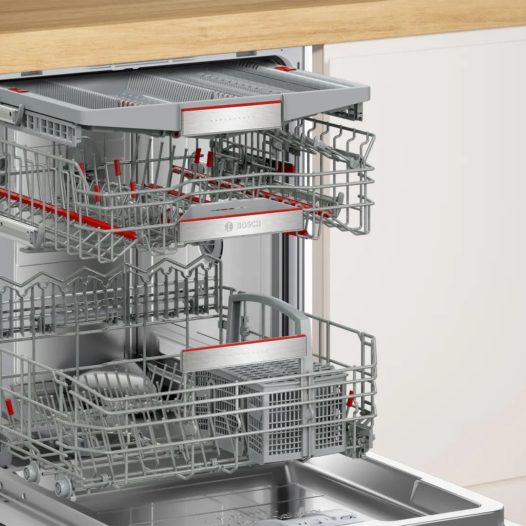 Open dishwasher showing the interior racks and cutlery baskets