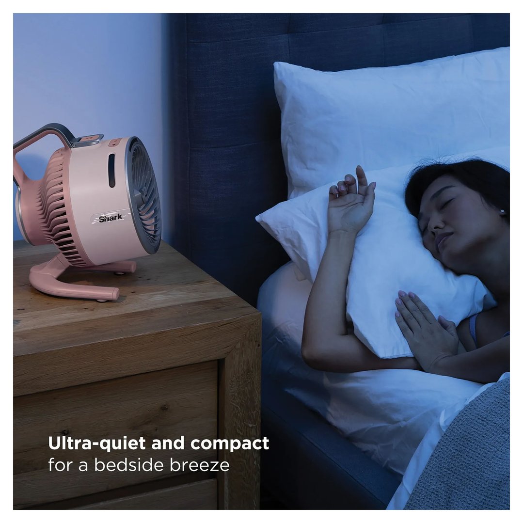 Pink Shark fan on a bedside table next to a sleeping woman