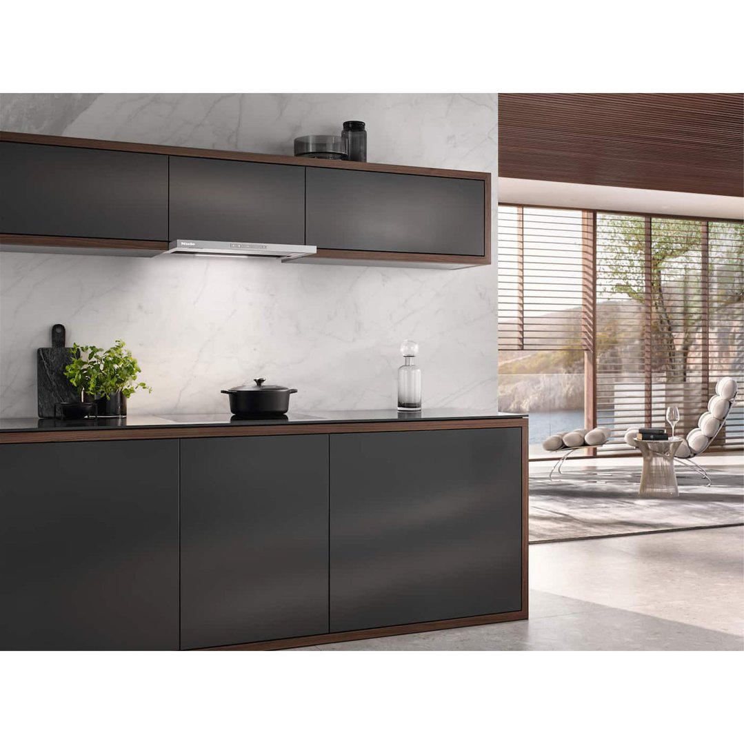 A Miele rangehood installed above a cooktop in a modern kitchen with a view