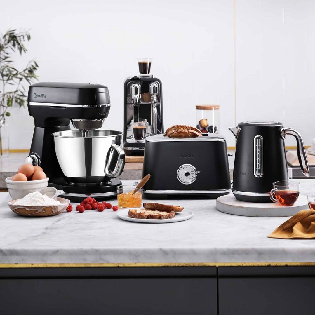 Breville food mixer, coffee machine, toaster, and kettle on a marble kitchen counter