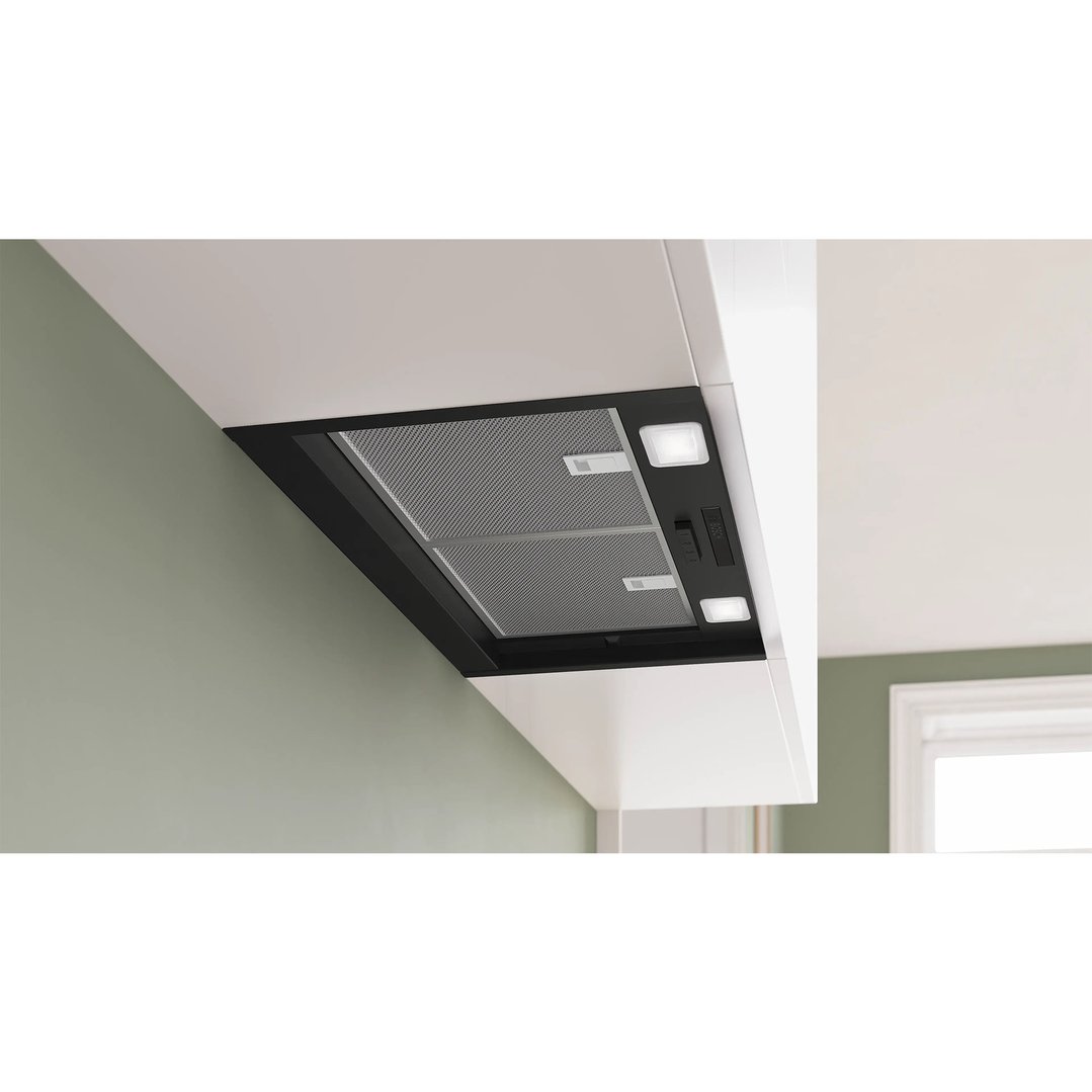 Integrated rangehood with lights and controls installed under a white kitchen cabinet