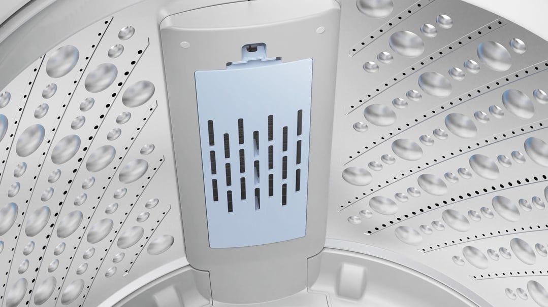 Close-up inside the washing machine drum, showing the filter and textured walls