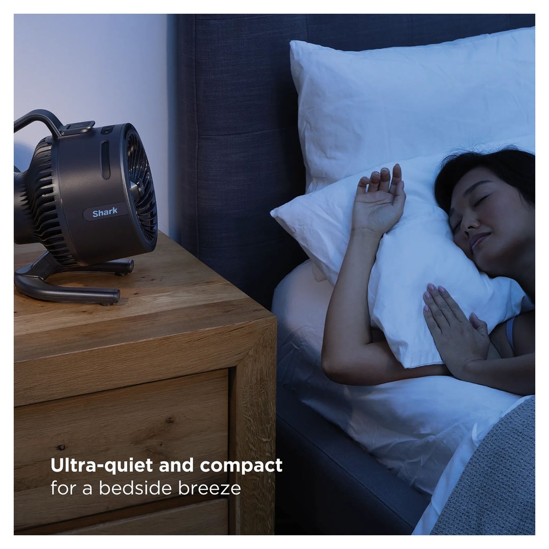 Shark FlexBreeze HydroGo misting portable fan on a bedside table next to a sleeping woman