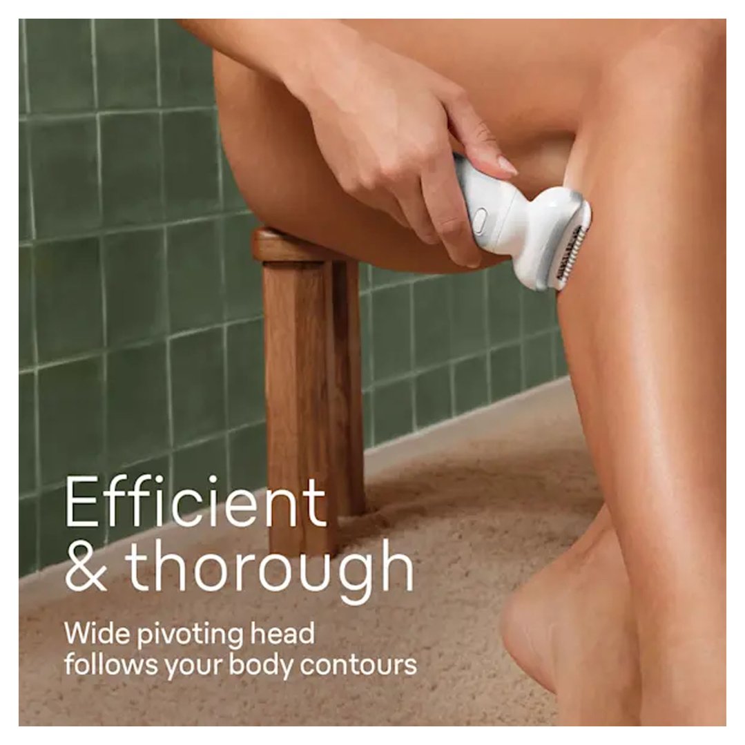 Woman using an epilator on her leg in a bathroom setting