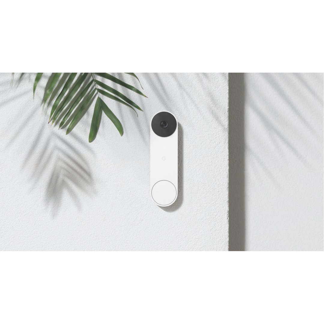 White Nest Doorbell on a textured wall with palm leaves and shadows