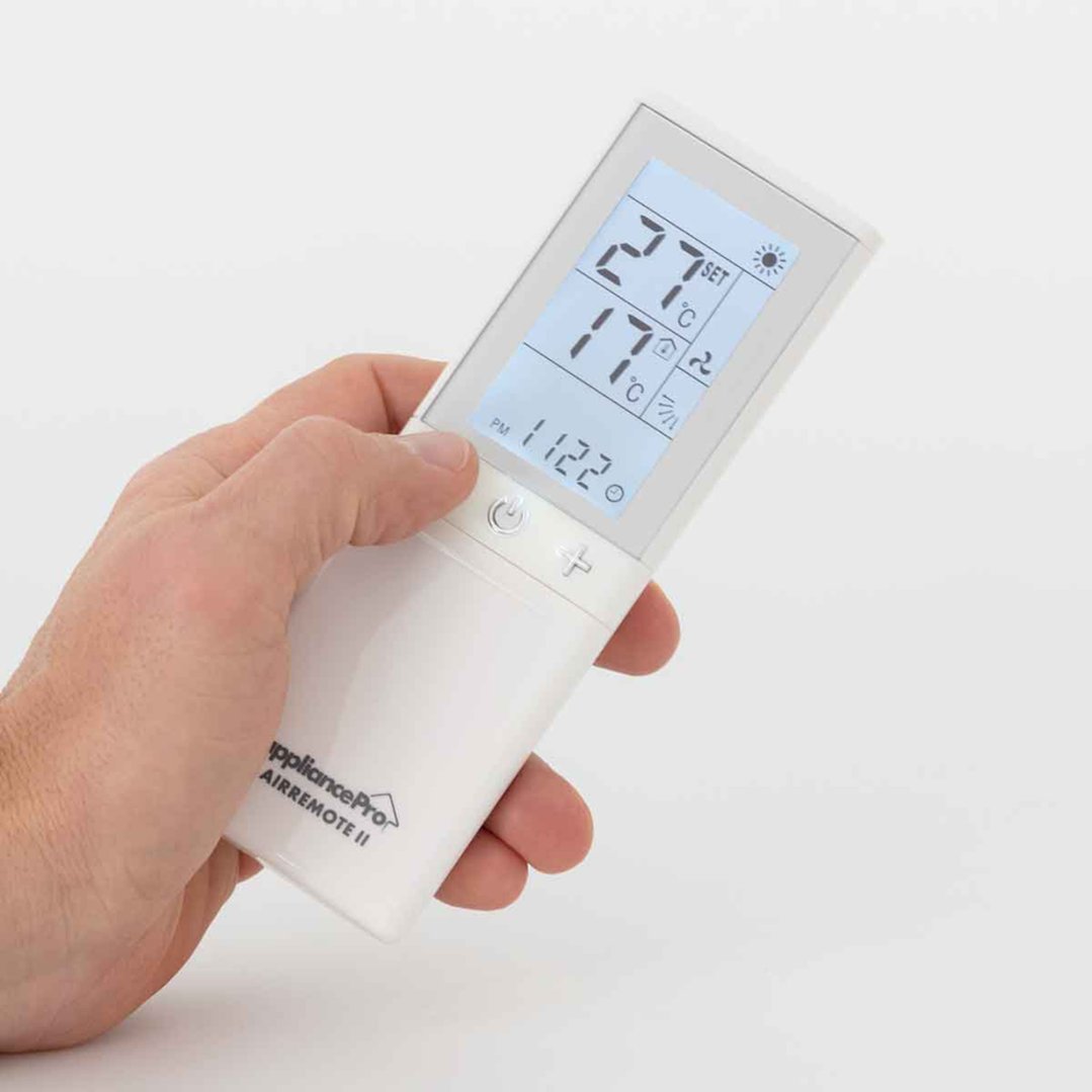 Hand holding a universal air conditioner remote with screen displaying settings