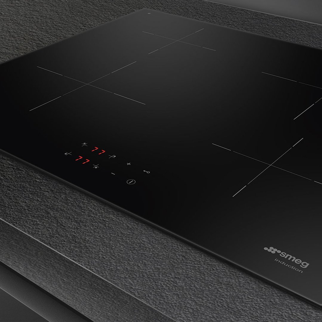 Black induction cooktop with illuminated controls, set into a dark countertop