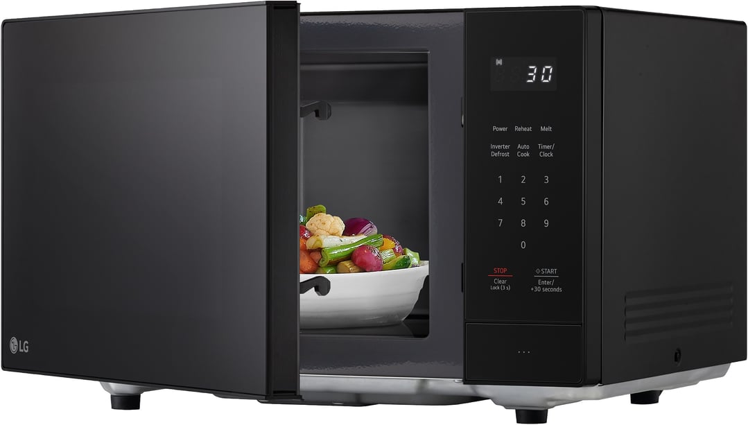 Black LG microwave with door open, showing a bowl of vegetables inside