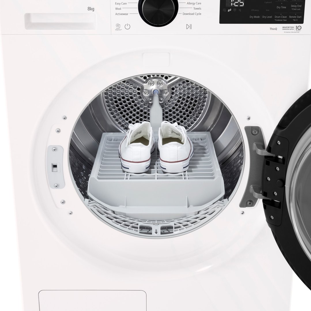 White LG dryer with door open, showing white sneakers on a drying rack