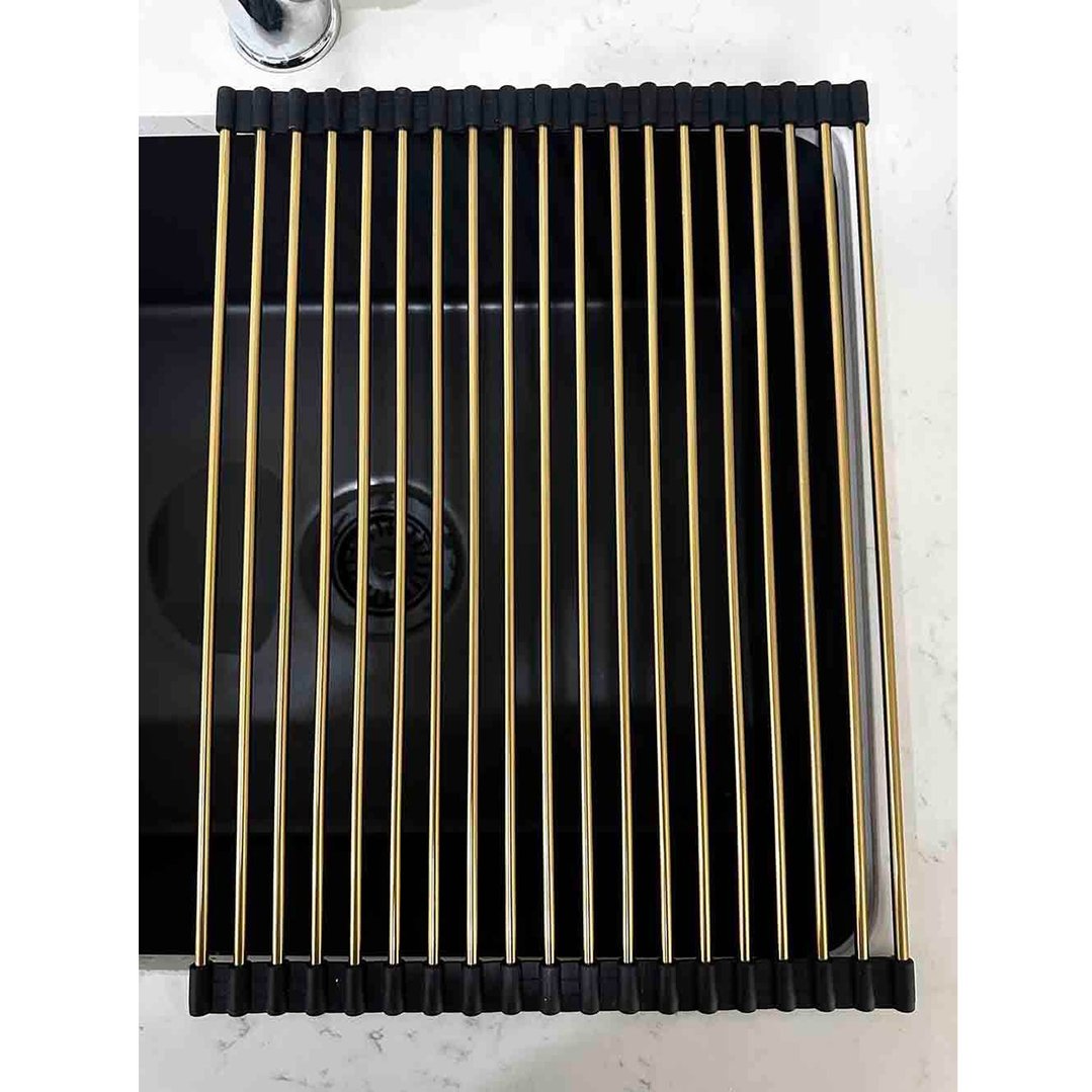 Brushed brass roll-up sink drainer placed over a black kitchen sink