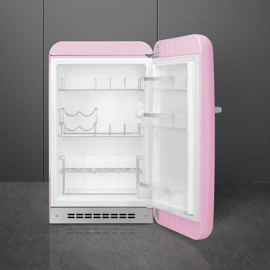 Pink retro refrigerator with door open, showing interior shelves and racks