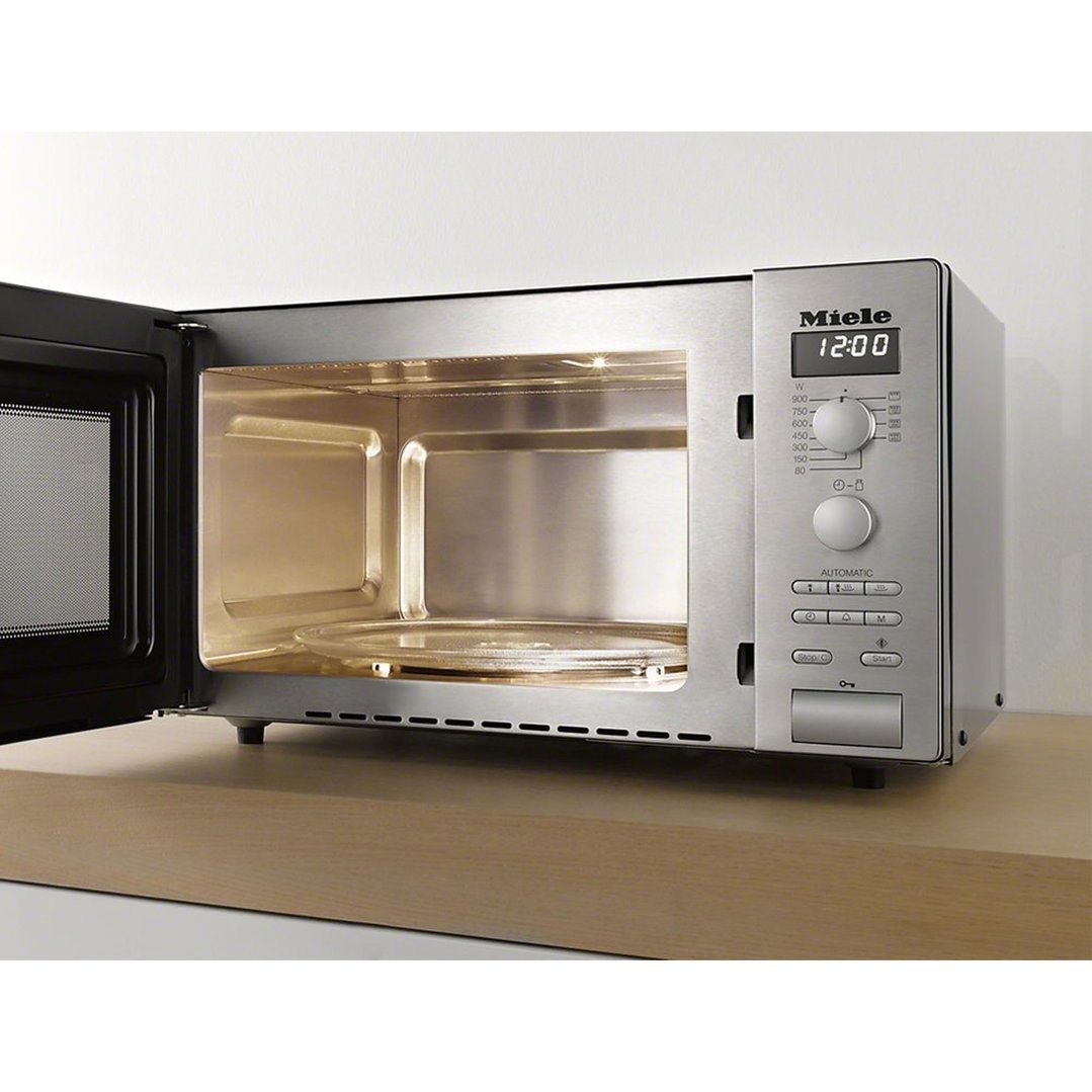 Stainless steel microwave oven with door open on a wooden benchtop