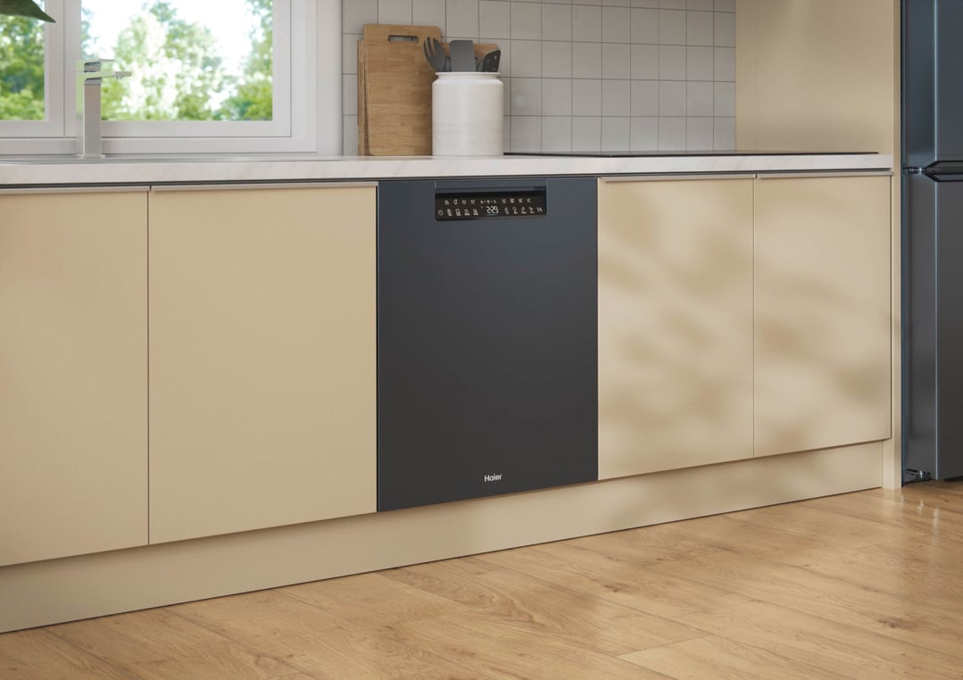 Black built-under dishwasher in a modern kitchen with light wood flooring