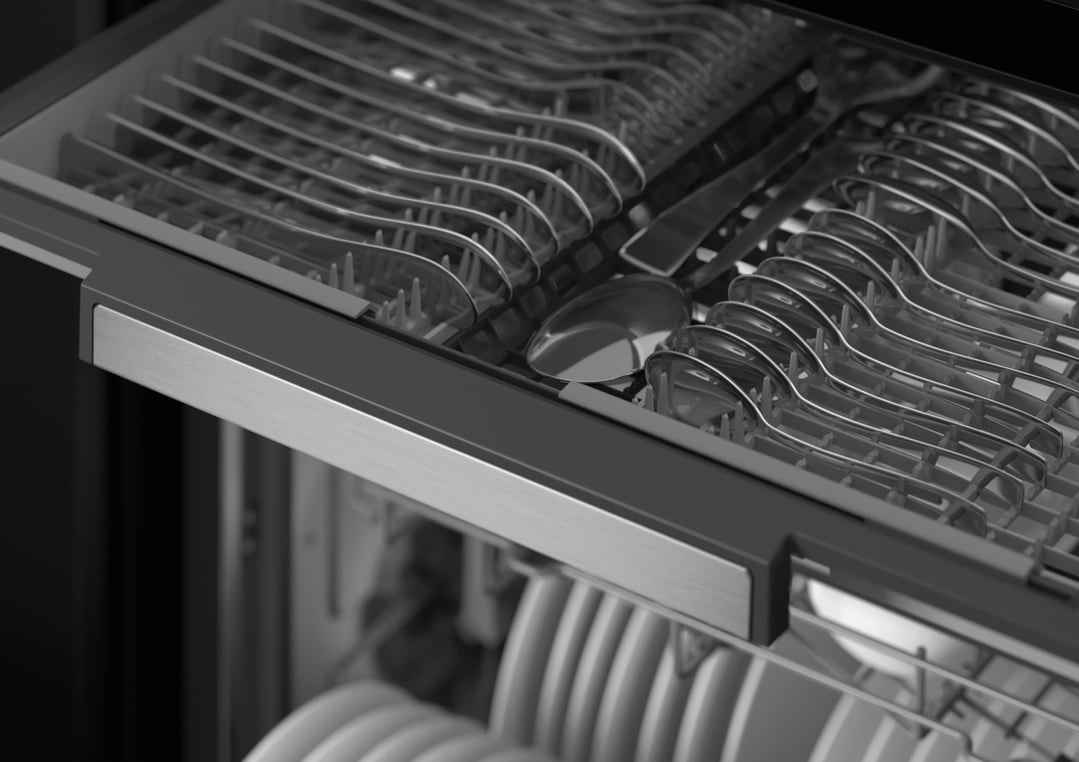 Close up of the top rack of a dishwasher filled with cutlery