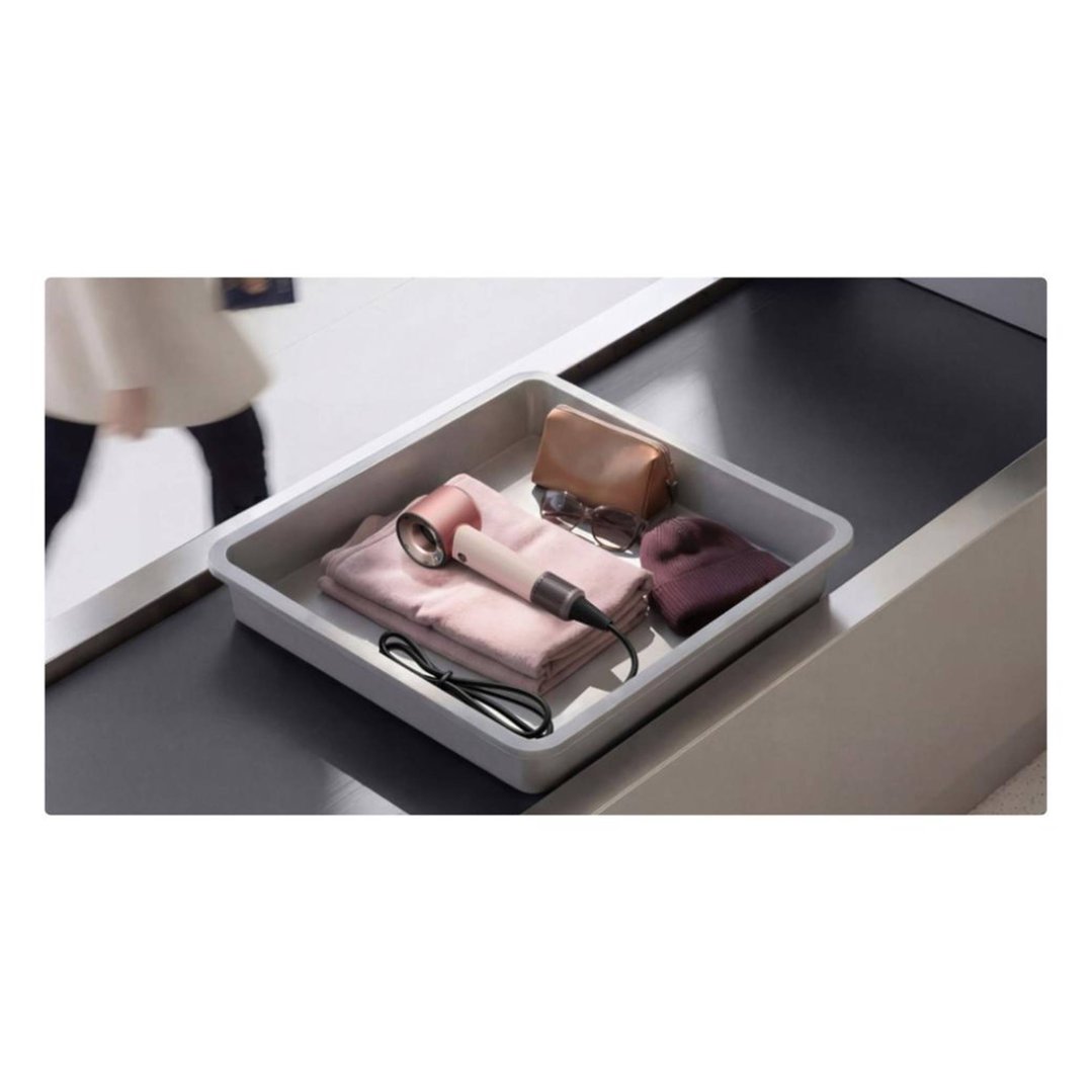 Dyson Supersonic Travel Hair Dryer in a tray with accessories at airport security