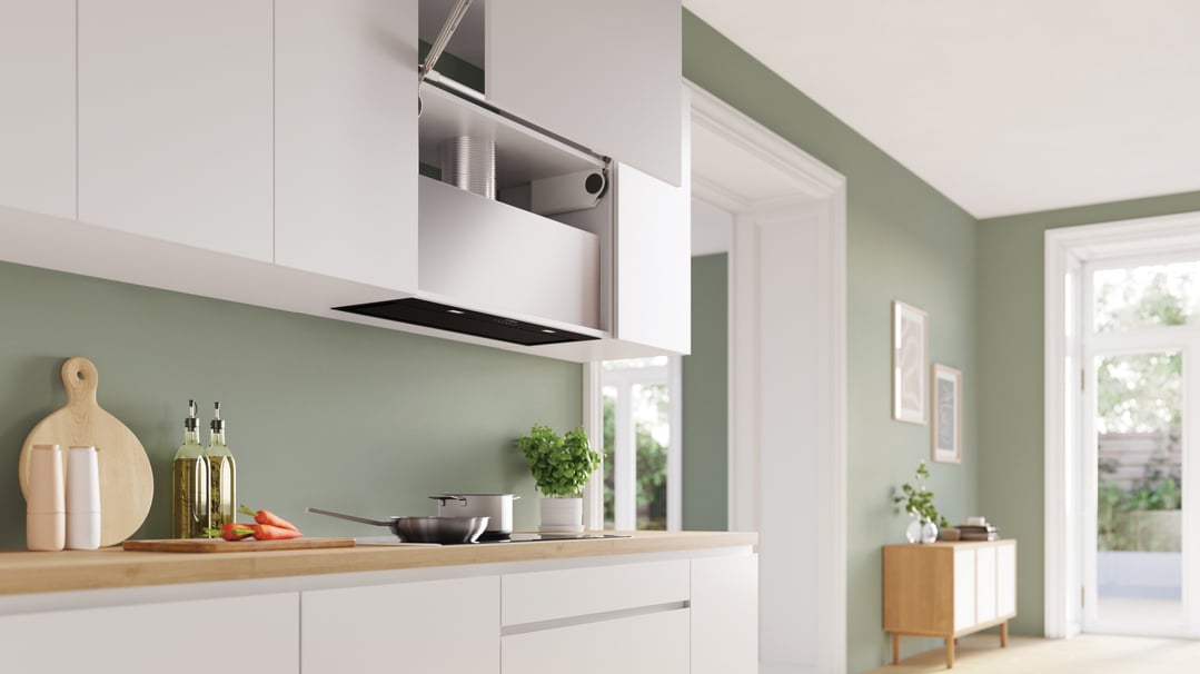 Integrated rangehood installed in a white kitchen cabinet above a wooden countertop