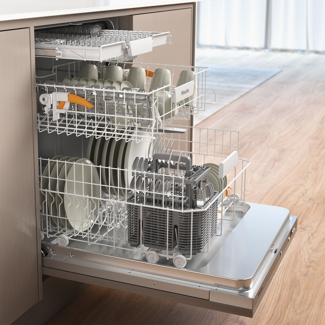 Open dishwasher with dishes and cutlery inside, in a kitchen setting
