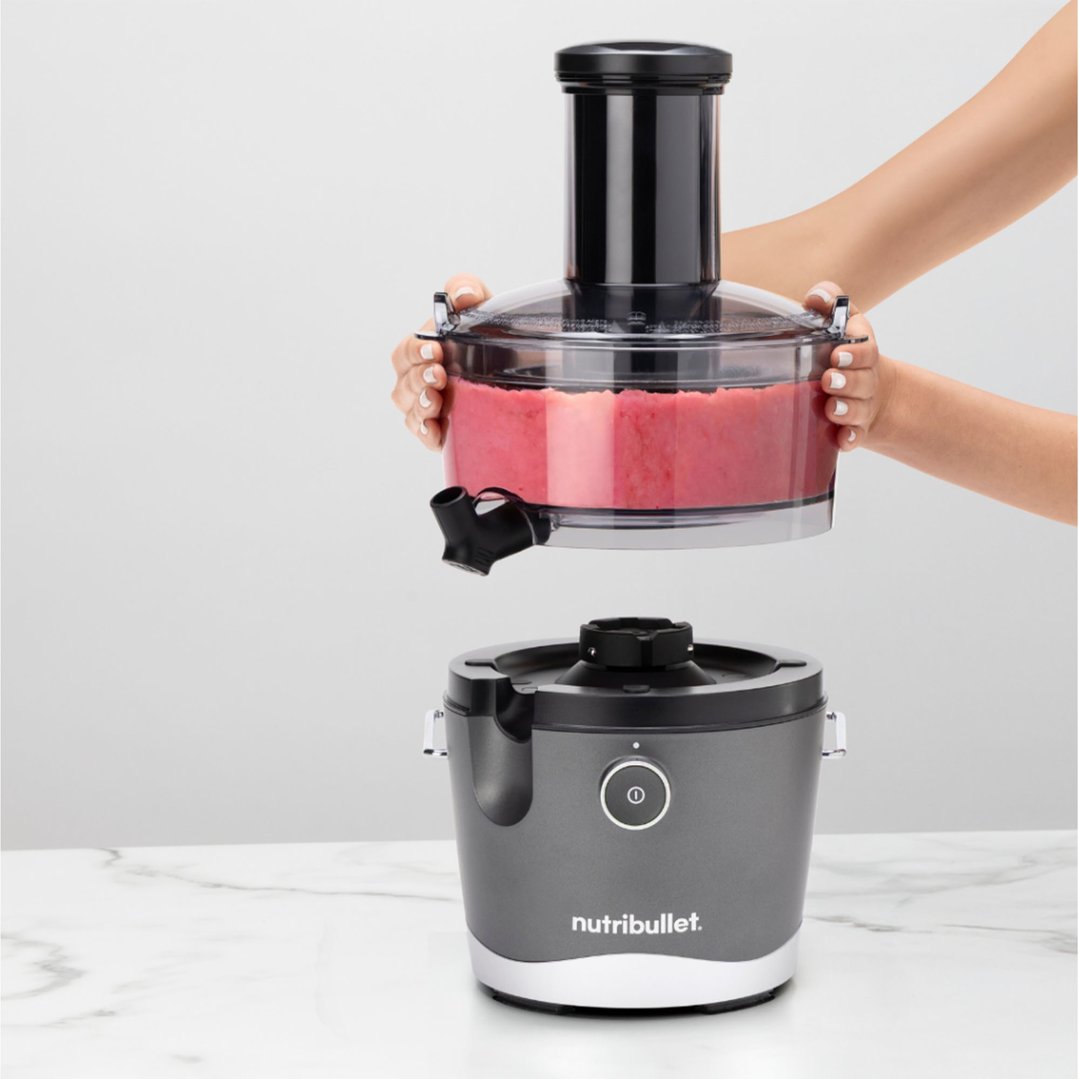 Hands placing the top part of the Nutribullet juicer onto its base