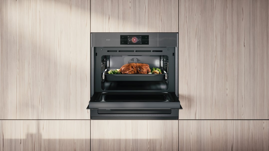 Built-in ASKO microwave oven with a roasted chicken and vegetables inside