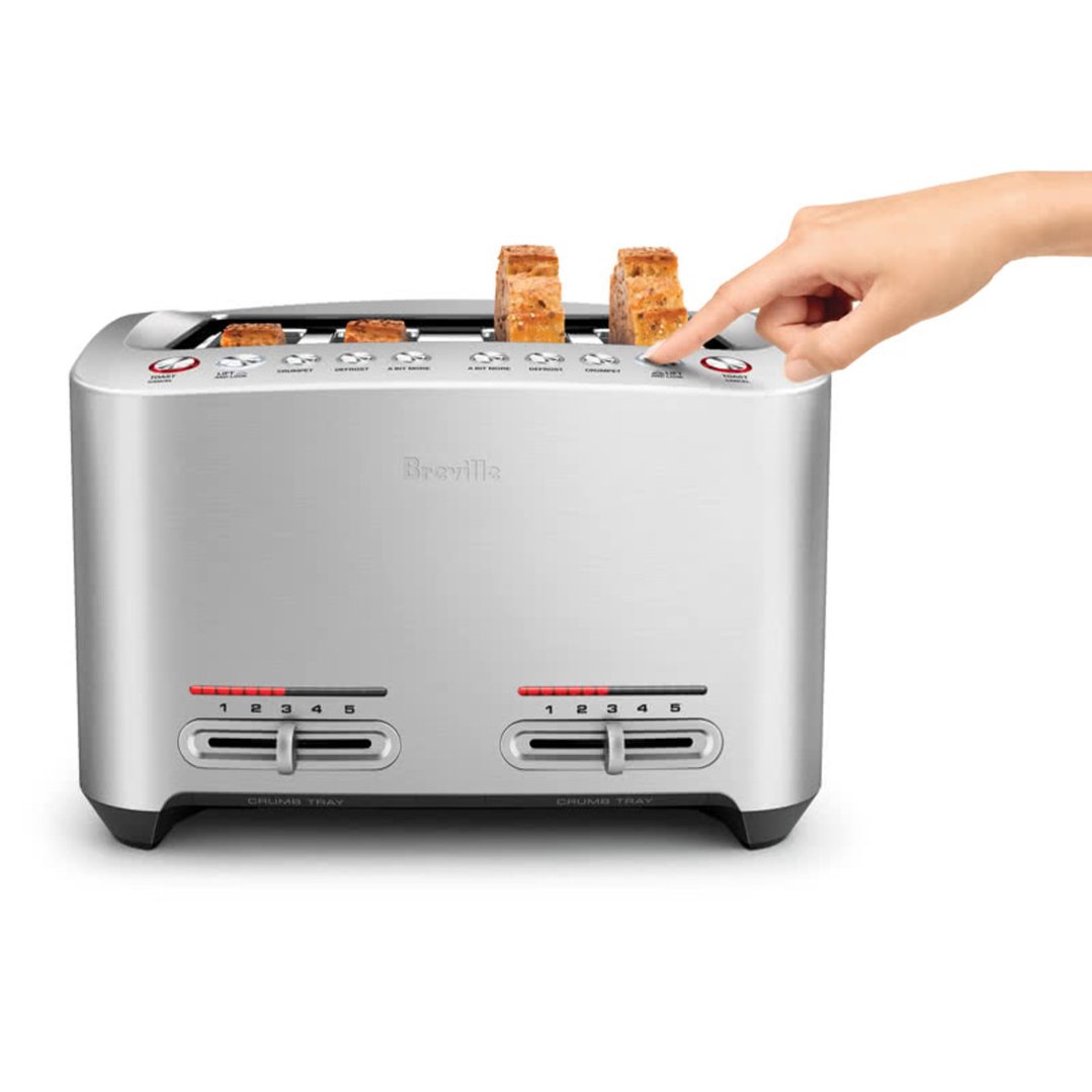 Hand pressing a button on a Breville toaster with toast inside