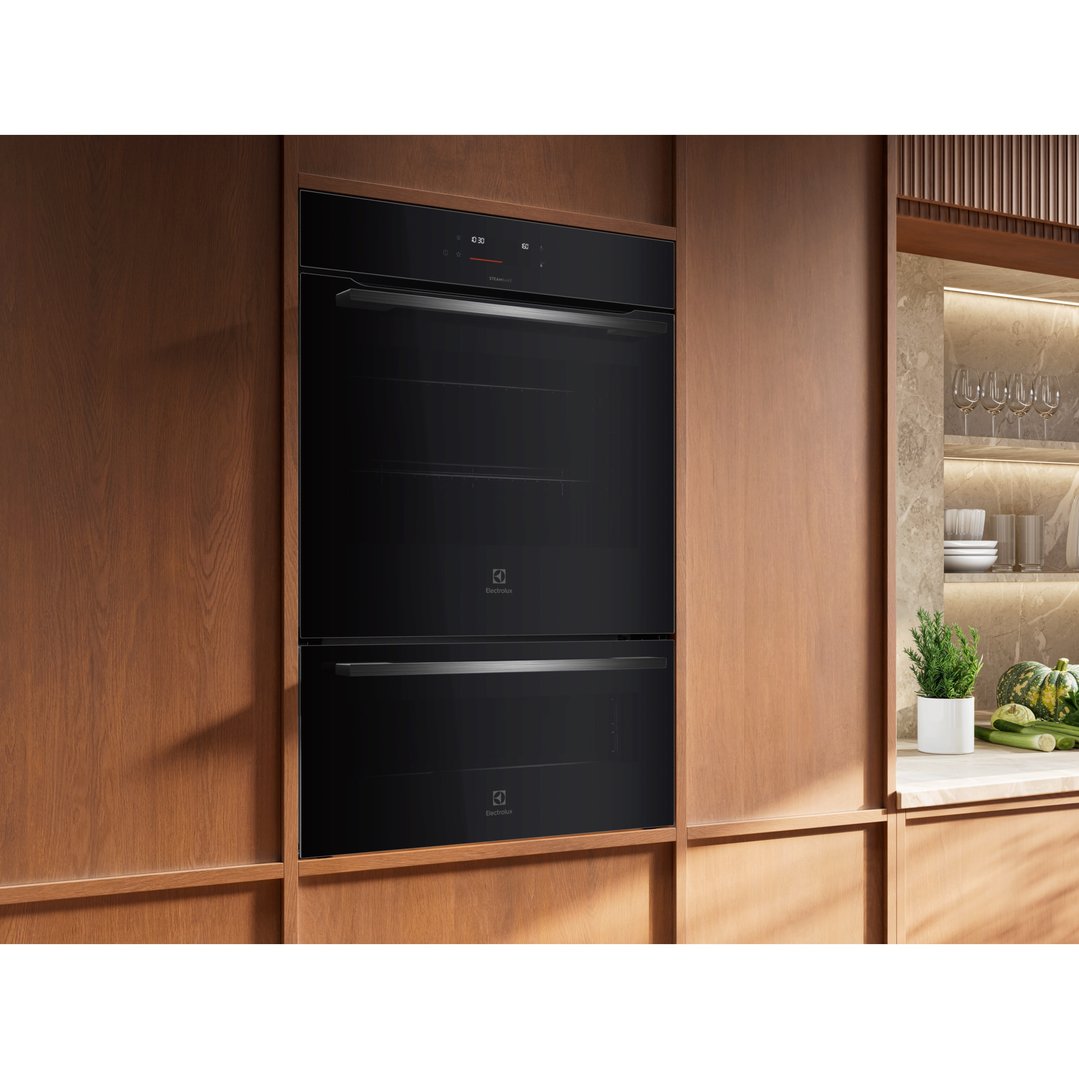 Black double oven built into wooden cabinetry in a modern kitchen