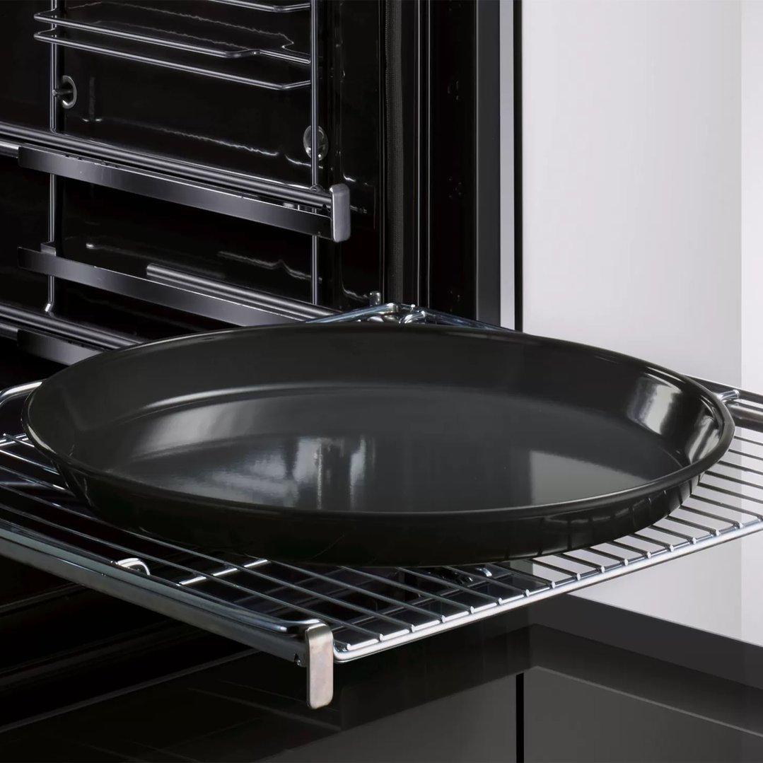 Pizza tray on a wire rack inside an open oven