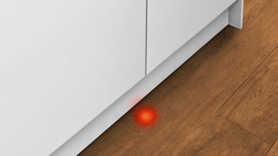 Red light projected onto the floor from a built-in dishwasher