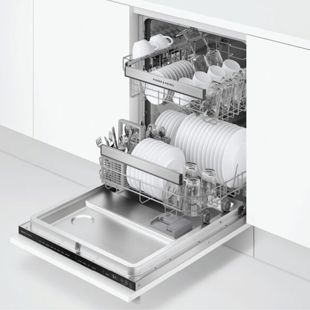 Integrated dishwasher with two racks full of dishes and cutlery, open in a kitchen