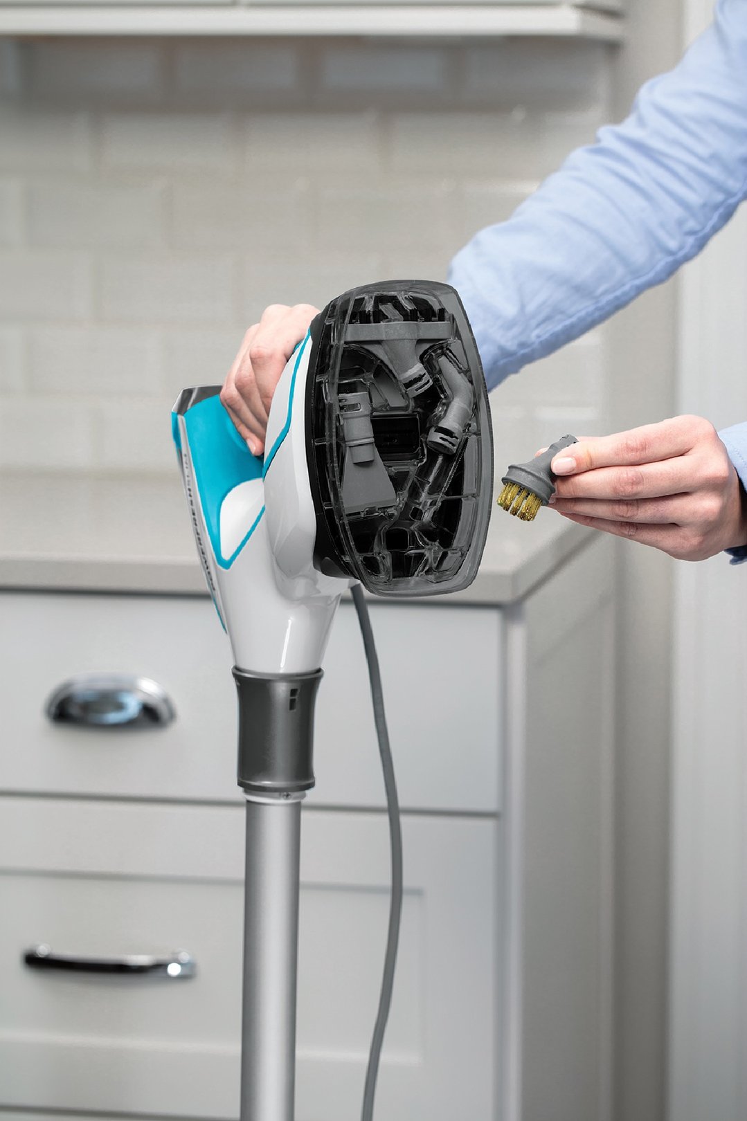 Person's hands holding a BISSELL PowerFresh Slim Steam Mop and a brush attachment