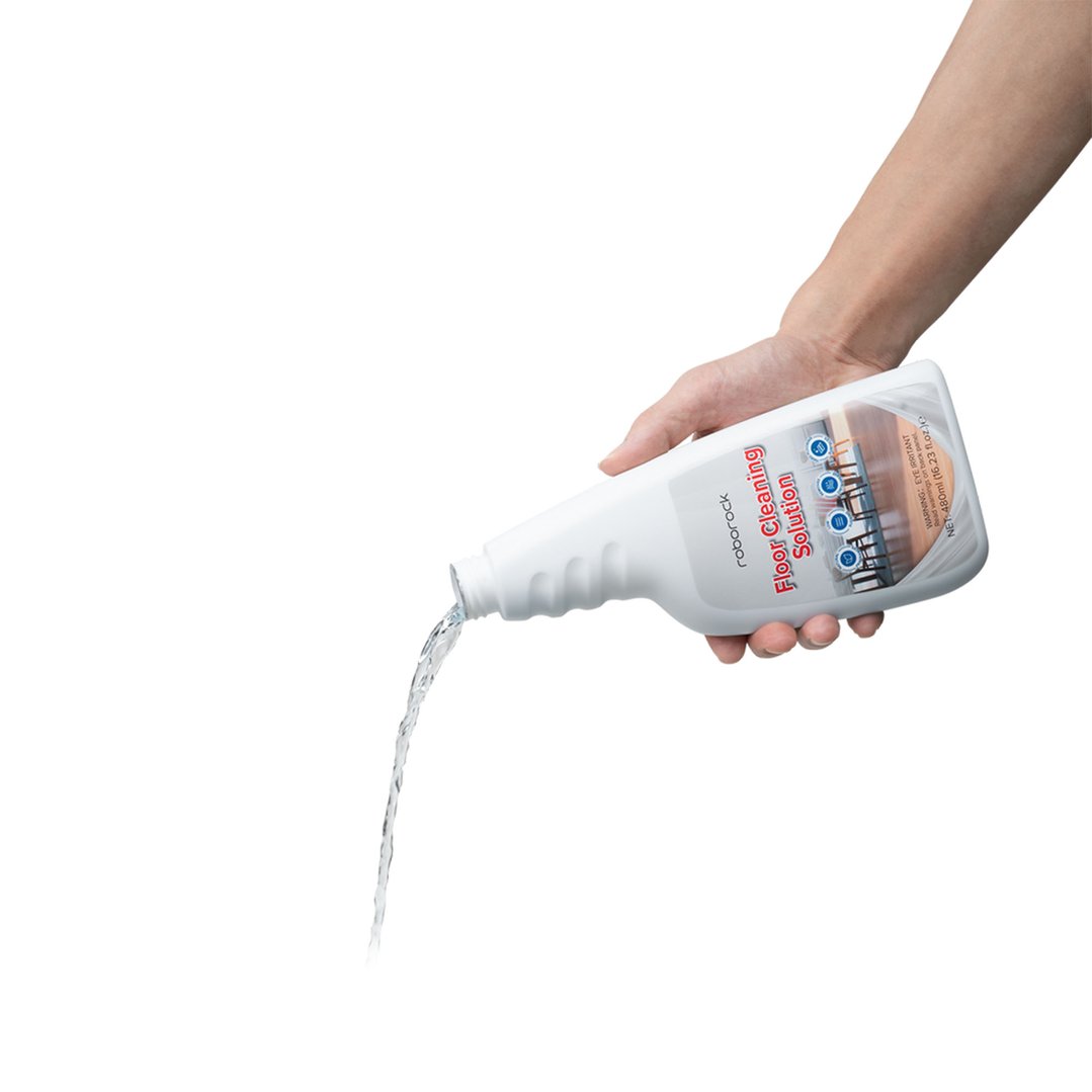 Hand pouring Roborock floor cleaning solution from a bottle, against a white background