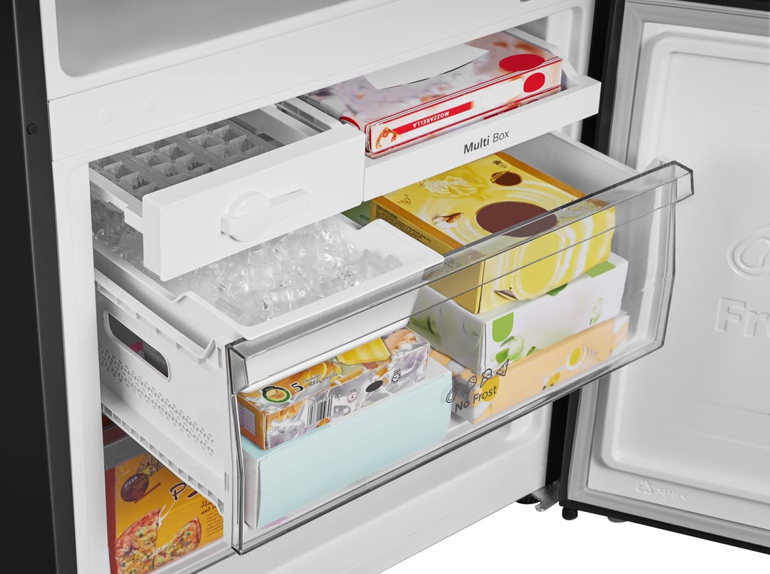 Open freezer compartment of a refrigerator with ice and various frozen foods