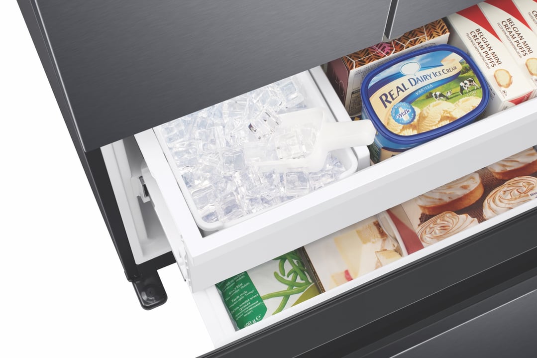 Open freezer drawer of a French door refrigerator showing ice and frozen foods