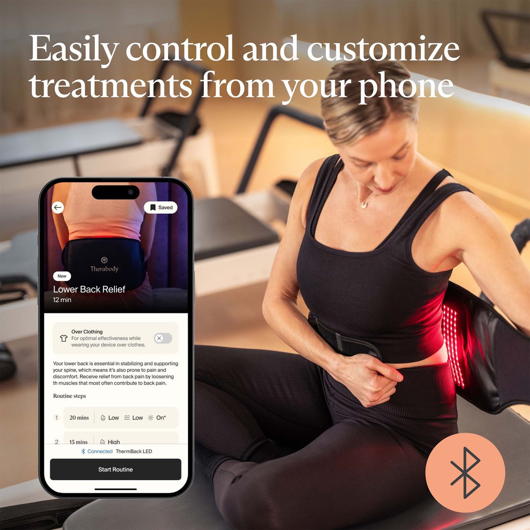 Woman using a ThermBack LED massager while controlling it with a smartphone app