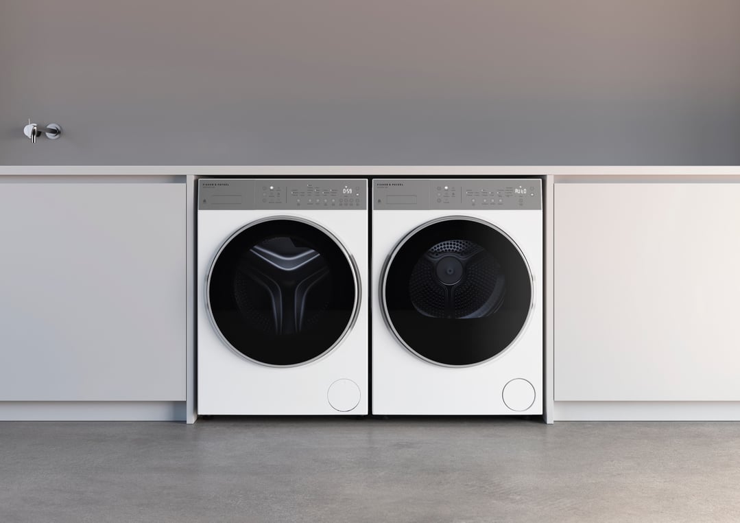 Two white washing machines installed under a counter in a modern laundry room