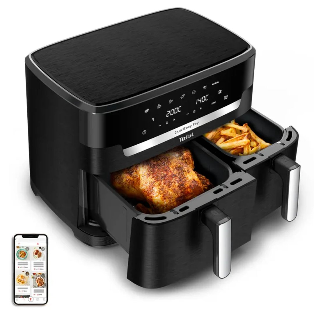 Black dual air fryer with whole chicken and fries, next to a smartphone