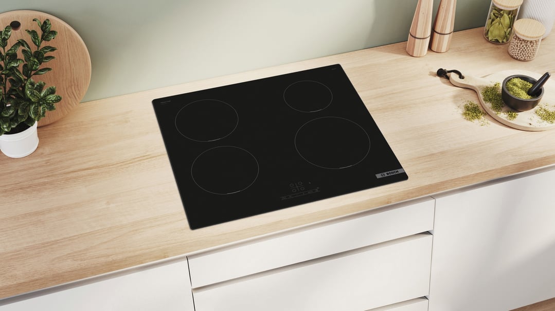 Black Bosch induction cooktop built into a light wood kitchen countertop